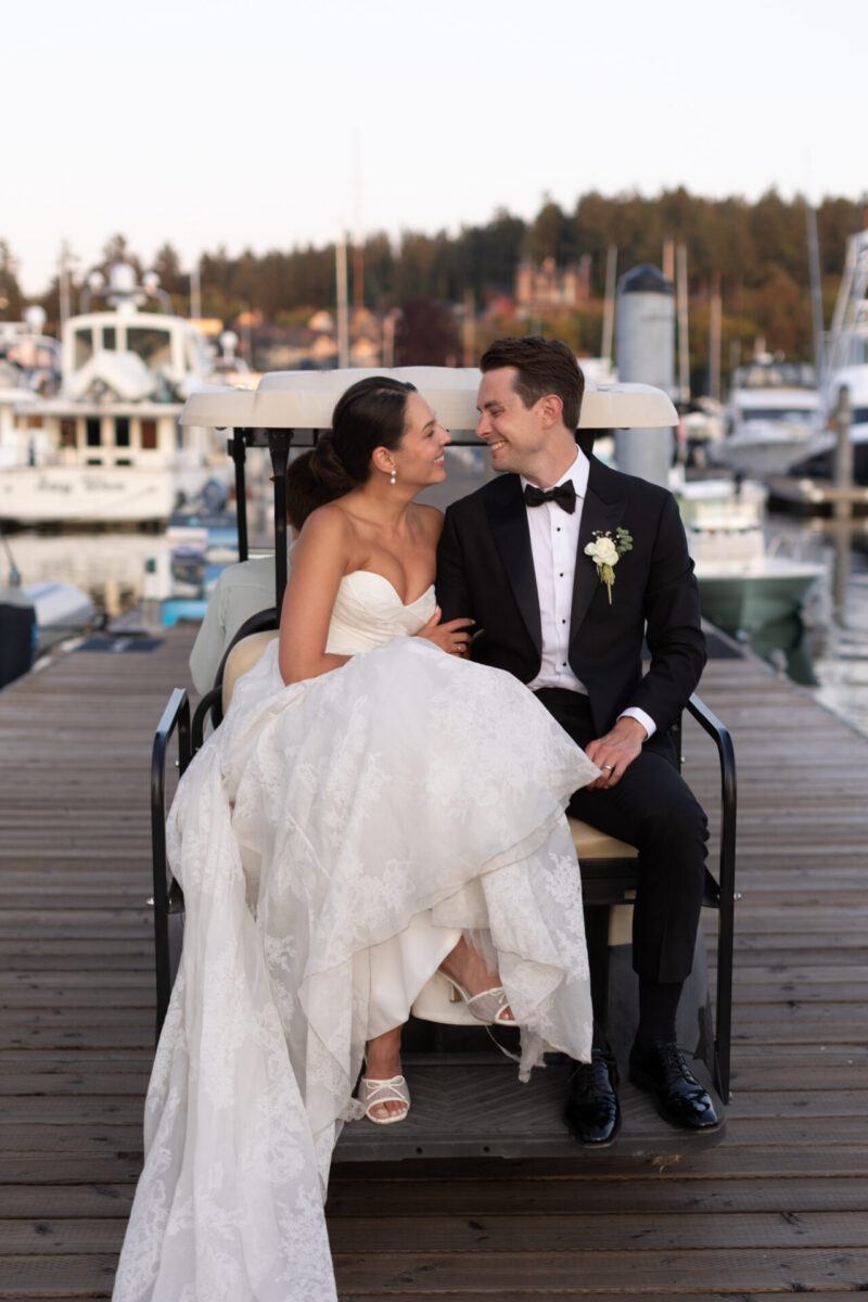 Bride and groom on a golf cart at a marina dock