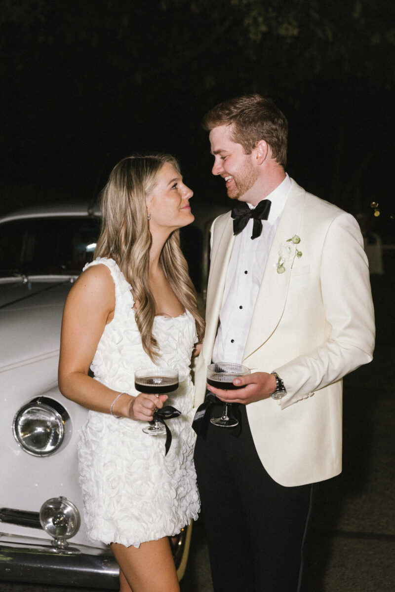 Bride and groom holding espresso martinis with flash photography