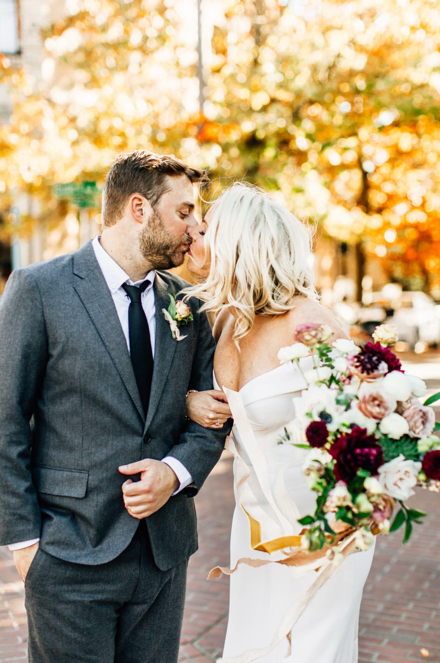 Fall leaves in Ballard with a bride and groom kissing, taken by a seattle wedding photographer